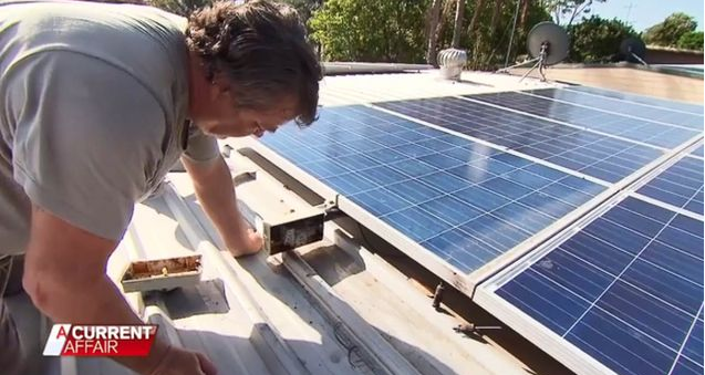 Ross Allan cleaning his solar panel installation on his roof. It is defective and has been disconnected for months after being installed by a dodgy solar business and its installers.